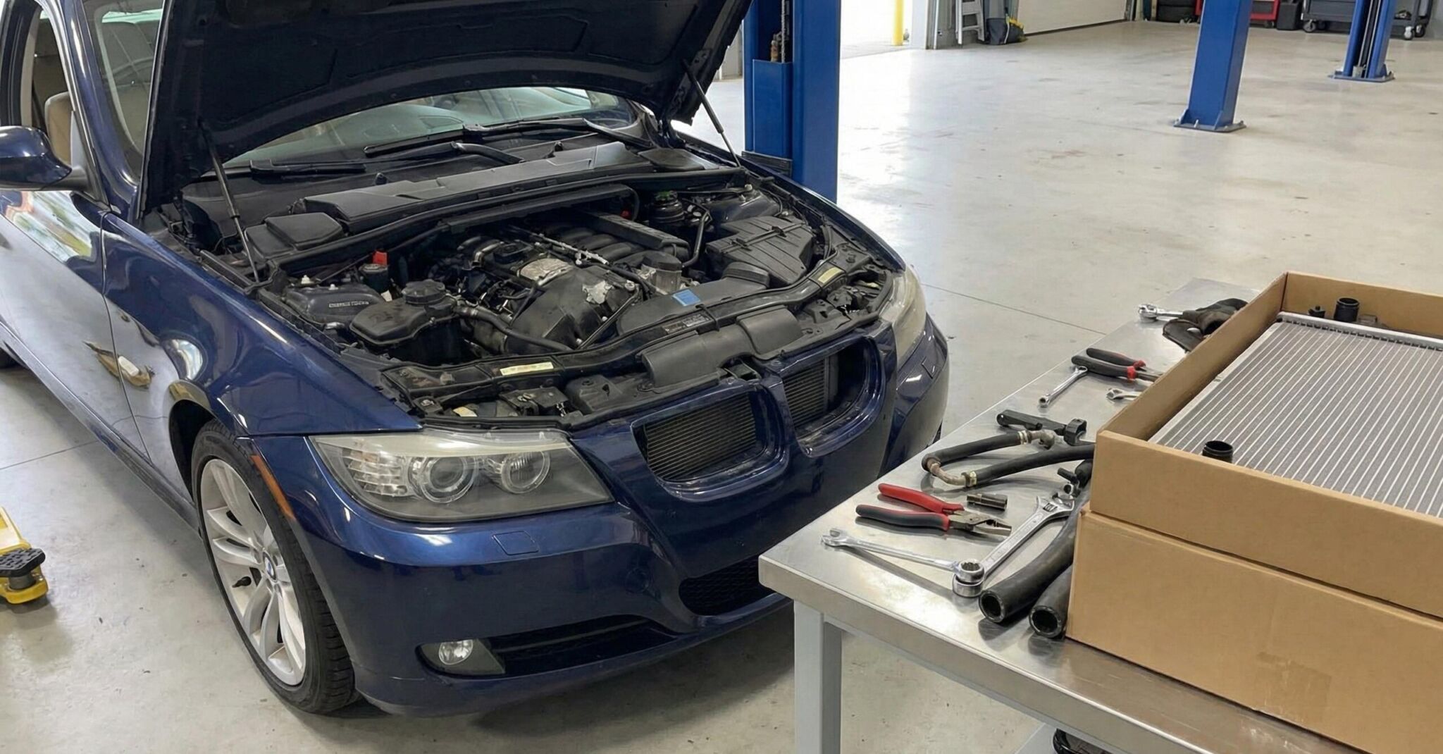 A blue car with its hood open in a garage